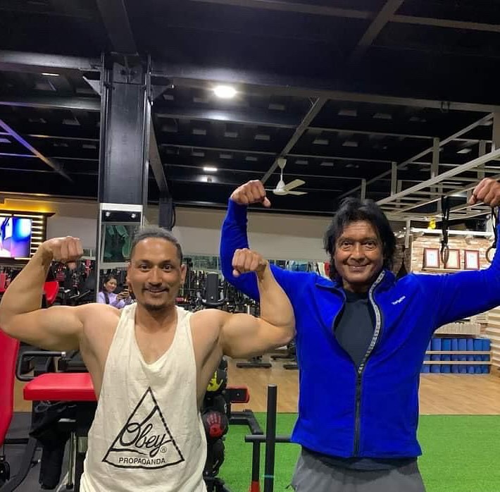 Two visitors posing together on the BobsGym training floor